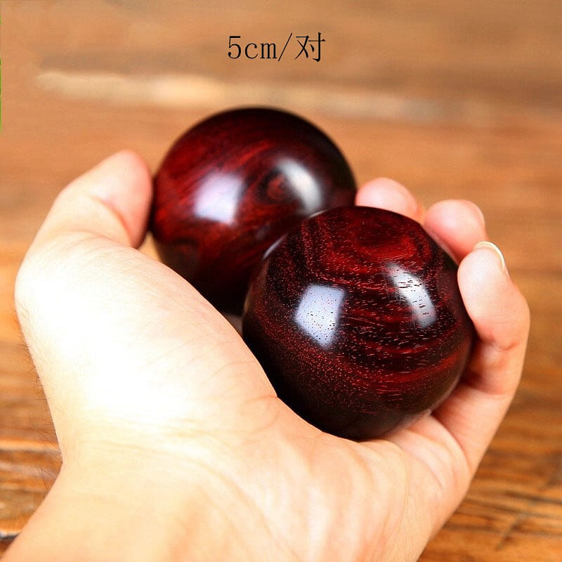 A pair of fitness balls carved from rosewood 1 each